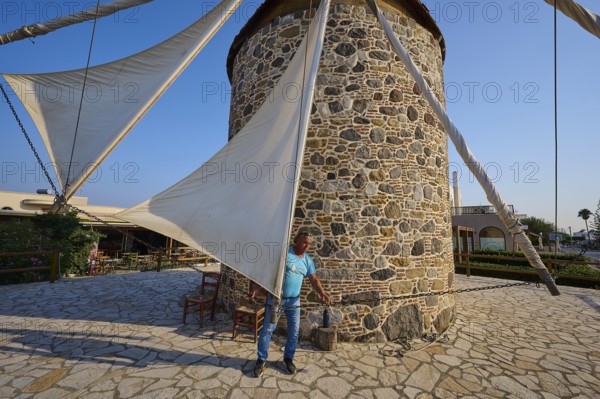 Stone windmill with a man fixing the sail, Windmill, Antimacheia, Kos, Dodecanese, Greek Islands, Greece