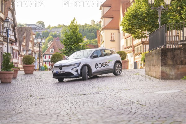 Renault drives through a picturesque town with cobblestones, Deer E, car sharing, electric car, Calw, Black Forest