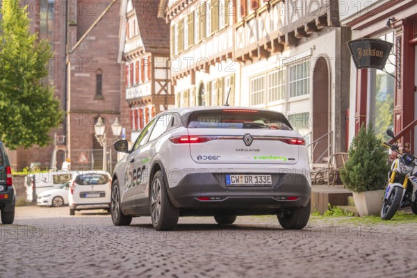 A car drives through a cobbled street in a traditional town, Deer E, car sharing, electric car, Calw, Black Forest