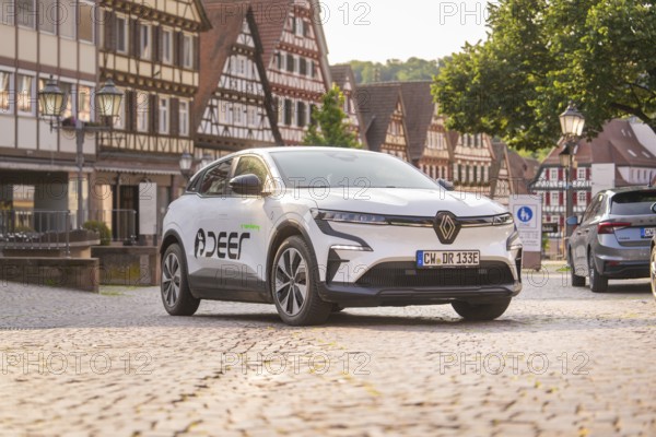 Car on a cobbled square surrounded by half-timbered buildings, summer atmosphere in the early evening, Deer E, car sharing, electric car, Calw, Black Forest