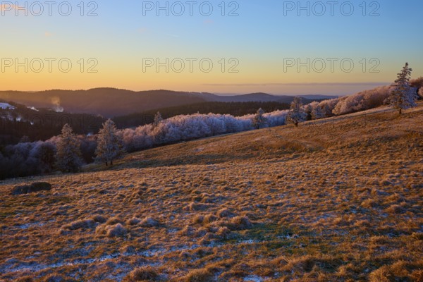 Frosty hills under a bright orange evening sky, winter, Route de Cretes, Hohneck, La Bresse, Vosges, France