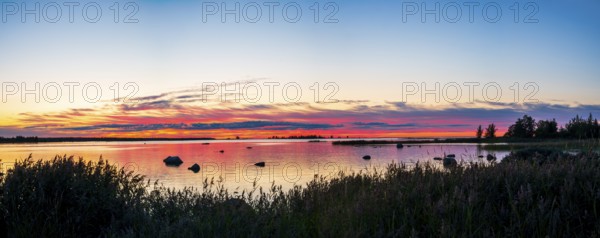 Colourful sunset over a calm lake with clouds, peaceful atmosphere, Svedjehamn, Kvarken Archipelago, Finland