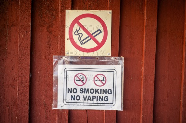 Red wall with no smoking signs prohibiting smoking and vaping, Svedjehamn, Kvarken Archipelago, Finland