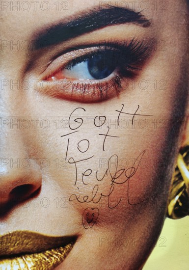 Large-scale advertising poster depicting a woman's face and the inscription Gott tot, Teufel lebt, Witten, North Rhine-Westphalia, Germany