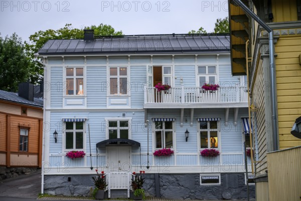 Street scene in the old town of Naantali, two-story light blue wooden house with balconies decorated with flowers. A calm, inviting sight, Naanatali, Varsinais-Suomi, Finland