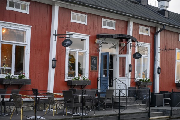 Red wooden café building with outdoor seating area, inviting and traditionally designed, Naanatali, Varsinais-Suomi, Finland