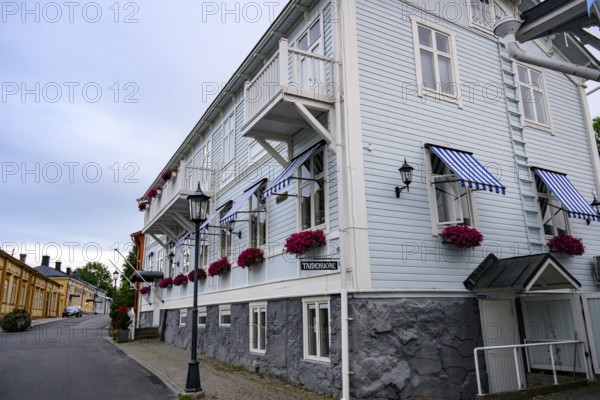Large historic building with balconies and blooming flowers, on a quiet street in the old town, Naanatali, Varsinais-Suomi, Finland