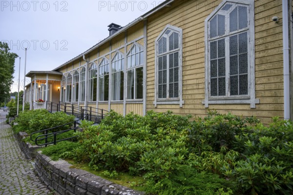 Street scene in the old town of Naantali, yellow building with tall, narrow windows and shrubs planted in front of it conveys peace, Naanatali, Varsinais-Suomi, Finland