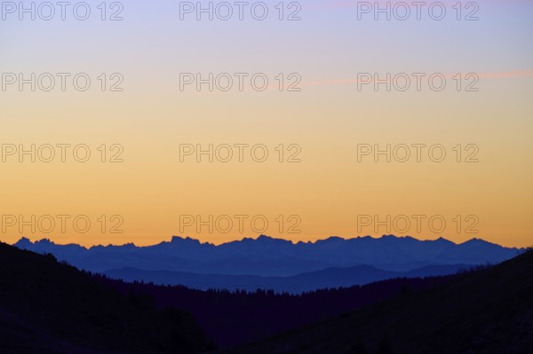 Mountains in silhouette at sunrise, sky in blue and orange, looking towards Alps, Hohneck, La Bresse, Vosges, France