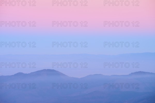 Pale hills in evening fog under a pink sky, looking towards the Rhine Valley, Hohneck, La Bresse, Vosges, France