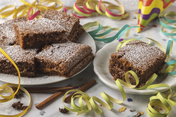 Spice cake with powdered sugar surrounded by colorful streamers and confetti