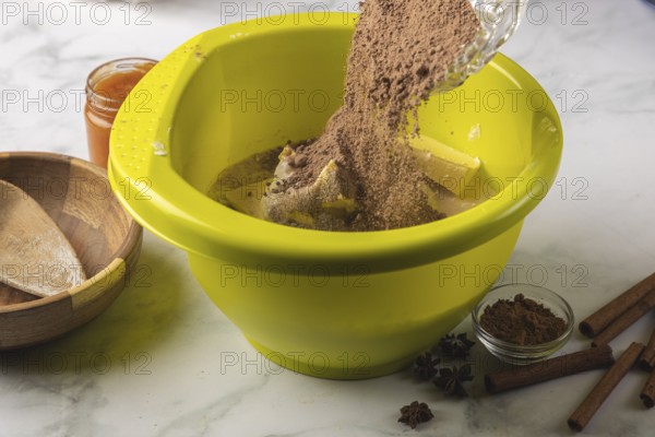 Cocoa is poured into a dough bowl with other ingredients