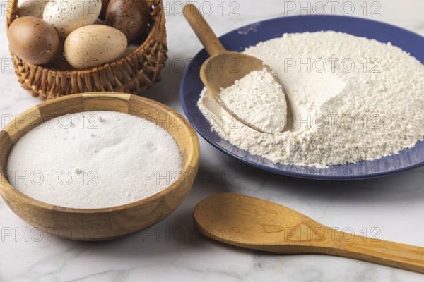 Baking ingredients such as flour, sugar and eggs with cooking spoon and flour scoop