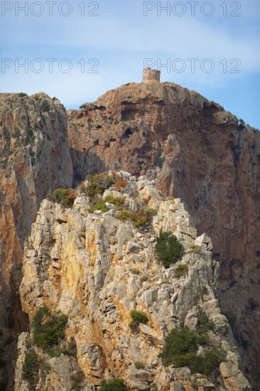 Bizarre rock formations on Capo Rosso, a Genoese tower blurred in the back, Piana, Corse-du-Sud department, west coast, Corsica, Mediterranean, France