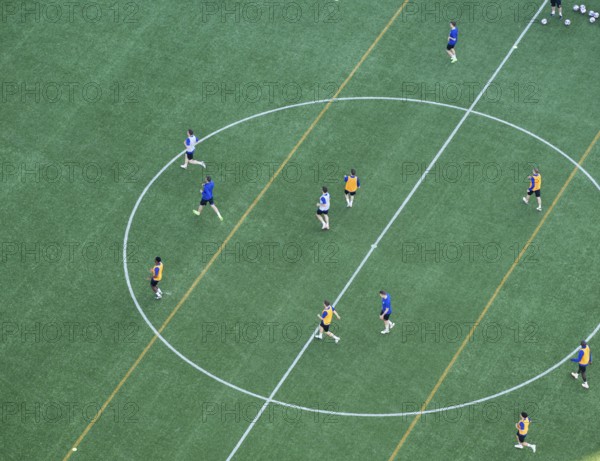 Players wearing colorful jerseys play soccer on a grass field from a bird's eye view from the tower of Helsinki Olympic Stadium, Finland