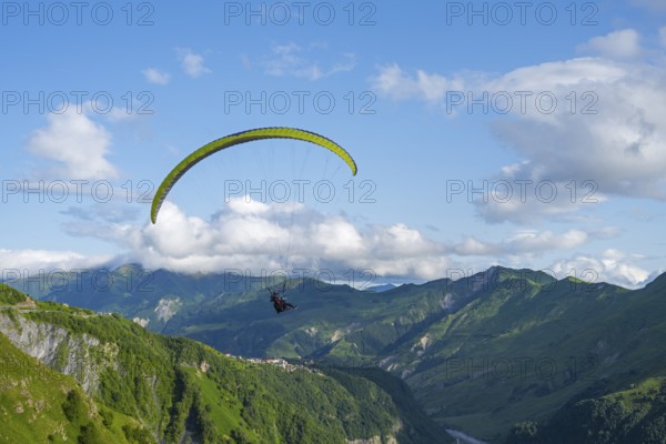 A paraglider in a vast mountain landscape with blue sky and white clouds, paraglider, paraglider near Gudauri, Mtskheta-Mtianeti region, Georgian Military Highway, High Caucasus, Georgia