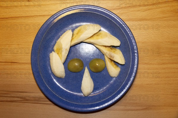 Fruit plate as a face, humor, banana, grapes