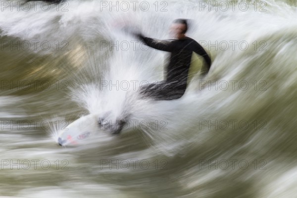 Surfers standing on Eisbach wave in the English Garden Munich, Upper Bavaria, Germany