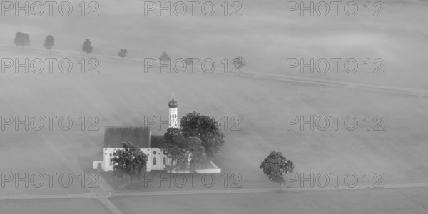 St. Coloman pilgrimage church in front of sunrise in autumn fog, Königswinkel, Ostallgäu, Allgäu, Bavaria, Germany