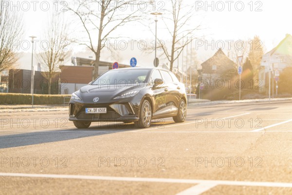 Modern car on a sunny street in an urban setting in the morning, MG4 electric car, Deer e-Carsharing, Calw, Germany