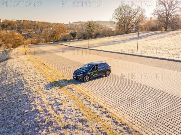 A car is parked in an empty, frost-covered parking lot on a sunny winter day, MG4 electric car, Deer E-Carsharing, Calw, Germany