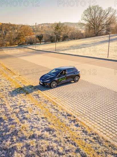 Car driving on a frosty road surrounded by early morning sunlight, MG4 electric car, Deer e-Carsharing, Calw, Germany