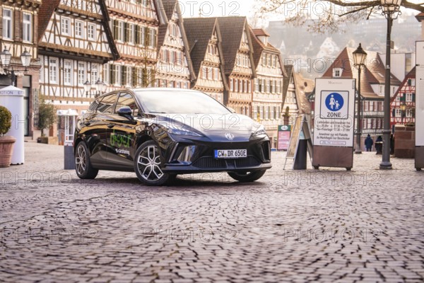 A car is parked in a historic old town with half-timbered houses and a charming atmosphere, MG4 electric car, Deer e-Carsharing, Calw, Germany