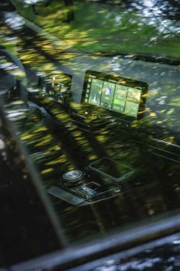 Car interior with reflective tree reflections and modern display on screen, MG4 electric car, Deer e-Carsharing, Calw, Germany
