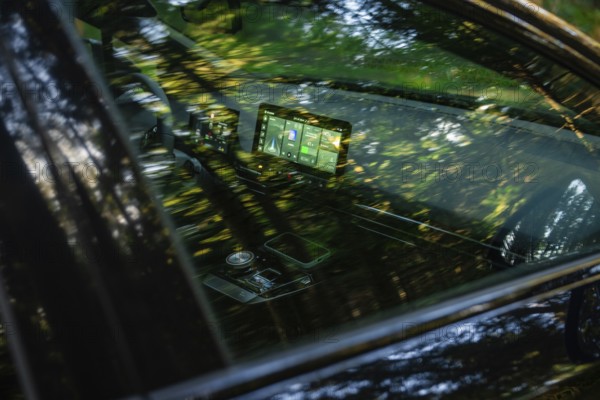 Modern car interior with screens, reflecting forest light and green ambiance, MG4 electric car, Deer e-Carsharing, Calw, Germany