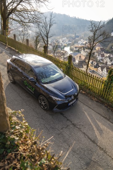 Car on a hill with a view of a village and a panoramic view of the surrounding area, MG4 electric car, Deer e-Carsharing, Calw, Germany