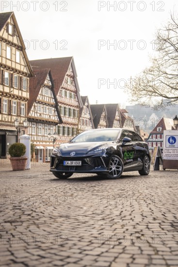 Car parked in a picturesque old town with half-timbered houses and paved streets, MG4 electric car, Deer e-Carsharing, Calw, Germany