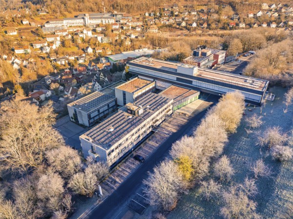 Aerial view of a large building complex surrounded by trees in an autumn landscape, MG4 electric car, Deer e-Carsharing, Calw, Germany