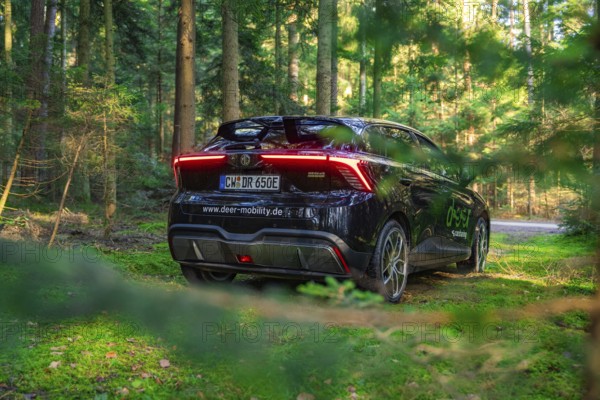 Carsharing car on a forest path surrounded by green nature, MG4 electric car, Deer E- Carsharing, Calw, Germany