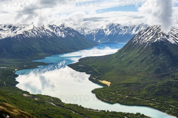 View of snowy mountains in spring and turquoise Kenai Lake with reflection, Slaughter Ridge Trail, Cooper Landing, Kenai Peninsula, Alaska, USA