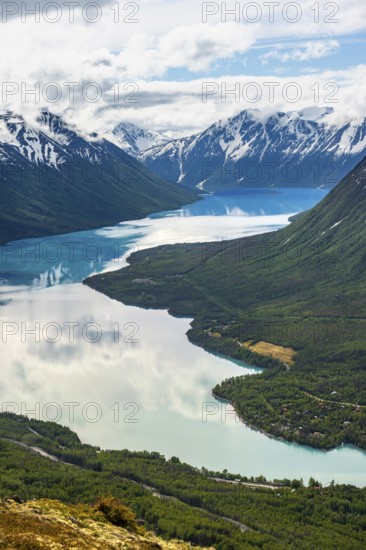 View of snowy mountains in spring and turquoise Kenai Lake with reflection, Slaughter Ridge Trail, Cooper Landing, Kenai Peninsula, Alaska, USA
