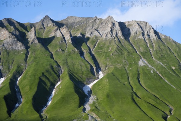 Steep green mountain ridges rise up under a blue sky, mountainous landscape between Gudauri and the Cross Pass, Mtskheta-Mtianeti region, Georgian Military Route, High Caucasus, Georgia