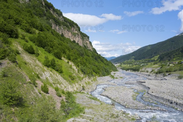 A river snakes through thick vegetation and steep cliffs, landscape near Kvemo Mleta, White Aragvi River, Mtskheta-Mtianeti region, Georgian Military Highway, High Caucasus, Georgia