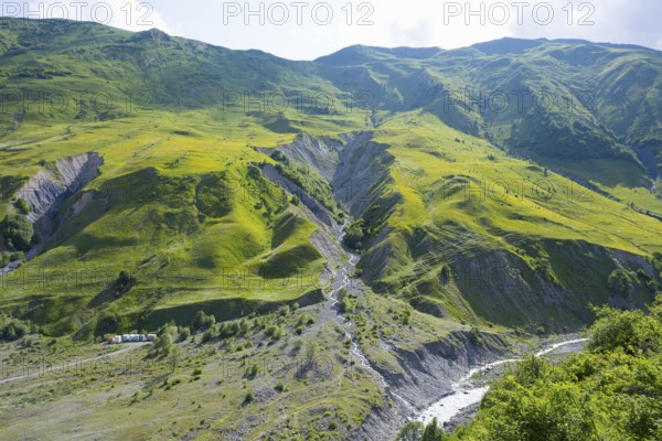 Green, steep landscape with a narrow river course in the mountains, landscape between Kvesheti and Gudauri, White Aragvi River, Mtskheta-Mtianeti region, Georgian Military Highway, High Caucasus, Georgia
