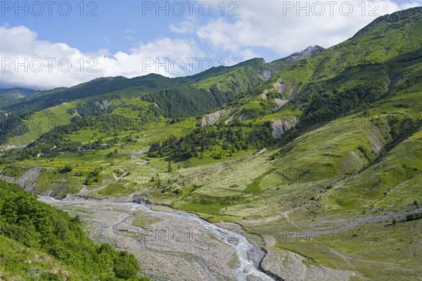 A river runs through wide valleys under a cloudy sky, landscape between Kvesheti and Gudauri, White Aragvi River, Mtskheta-Mtianeti region, Georgian Military Highway, High Caucasus, Georgia