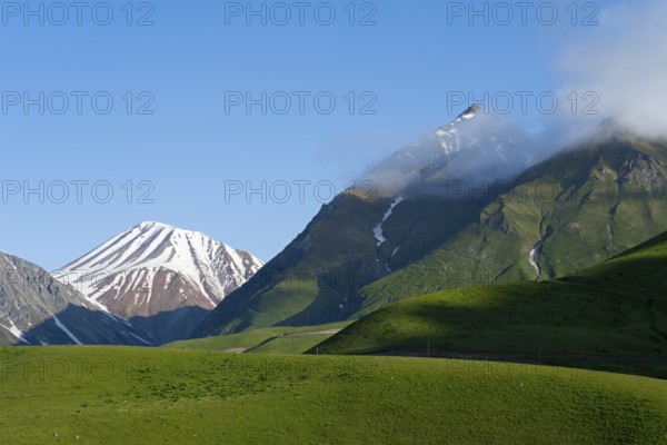 Hilly landscape with snow-capped peaks and clouds, landscape between Kvesheti and Gudauri, Mtskheta-Mtianeti region, Georgian Military Route, High Caucasus, Georgia