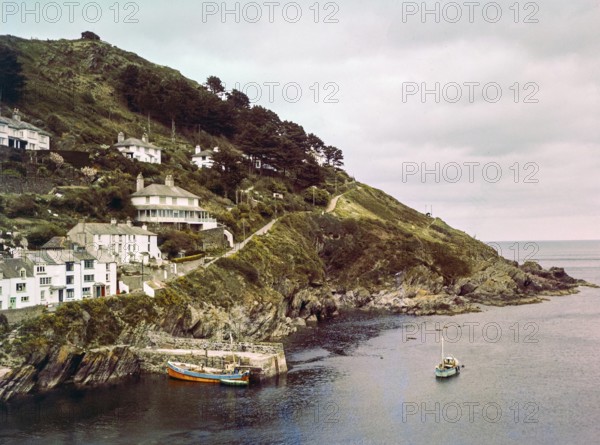 Historic waterfront buildings around the harbour river mouth of the River Pol at village of Polperro, Cornwall, England, UK
