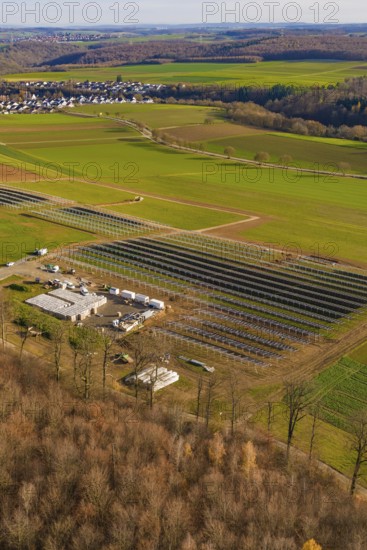 Solar system and building nestled in a green landscape with village surroundings in autumn, energy revolution, construction of PV open space, Baden-Württemberg, Germany