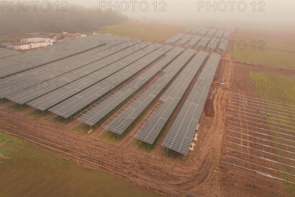 Solar fields under fog, sustainable energy in a wide field landscape, energy revolution, construction of PV open space, Baden-Württemberg, Germany