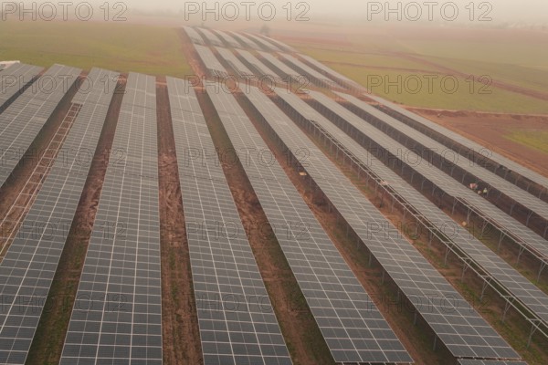 Extensive solar panel layout in foggy landscape, sustainable energy source, energy transition, construction of PV open space, Baden-Württemberg, Germany