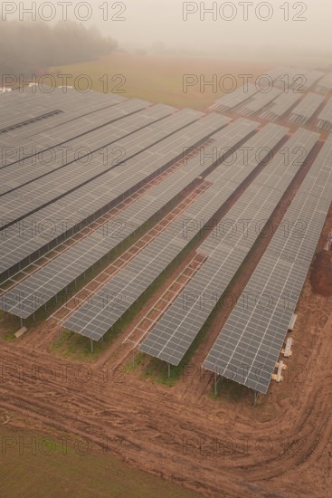 Foggy fields with solar panels, highlights rural and sustainable energy production, energy transition, construction of PV open space, Baden-Württemberg, Germany