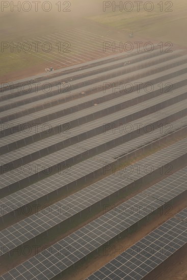 Arranged rows of solar panels on field, foggy atmosphere with structured pattern, energy transition, construction of PV open space, Baden-Württemberg, Germany