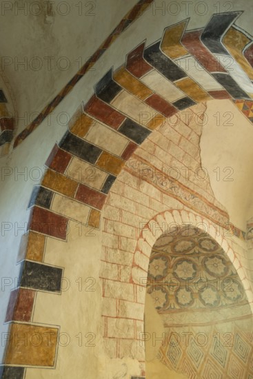 Painted arch in red, yellow and black. St Aignan's Church of Begues. Allier department. Auvergne Rhone Alpes. France. Europe