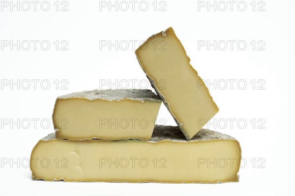 Three pieces of Saint-Nectaire cheese are stacked on top of each other. Puy de Dome. Auvergne. France