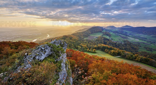View from the Gisliflue of an autumn-colored forest, behind the Jurassic foothills with water fluh and stripes in the light of the setting sun, Talheim, Canton, Aargau, Switzerland
