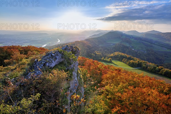 View from the Gisliflue of an autumn-colored forest, behind the Jurassic foothills with water fluh and stripes in the light of the setting sun, Talheim, Canton, Aargau, Swiss flag in the stern of the motor ship Brunnen in Fahr, Lake Lucerne, Brunnen, Canton of Schwyz, Switzerland